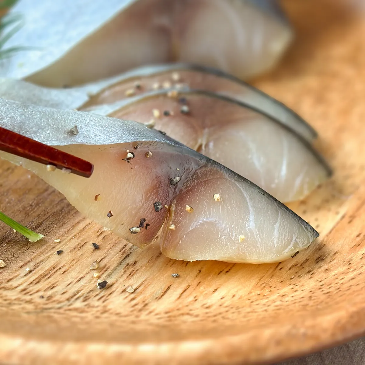 金華さば生ハム燻製を持ち上げている画像